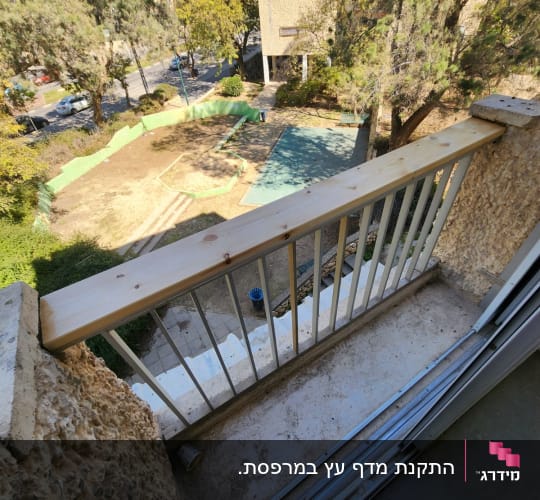 מעקה מרפסת עם לוח עץ חדש מותקן